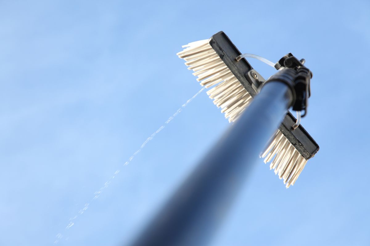  Detailed view of a broom mounted on a pole, highlighting the bristles and the connection point between the two.